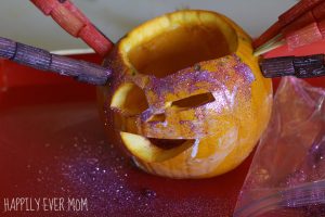 Adding glitter to the noodle pumpkin from Happilyevermom